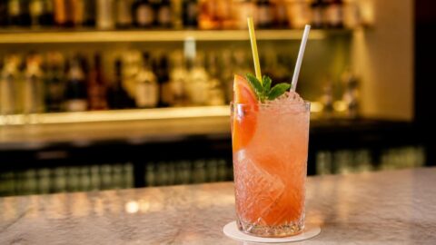 Craft cocktail garnished with a pasta straw and compostable straw on a Sydney bar top